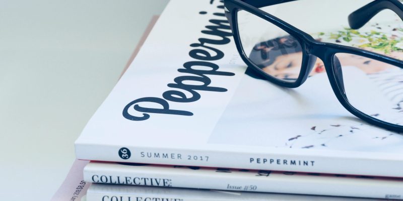 Eyeglasses on a stack of fashion and lifestyle magazines including Peppermint and Collective.